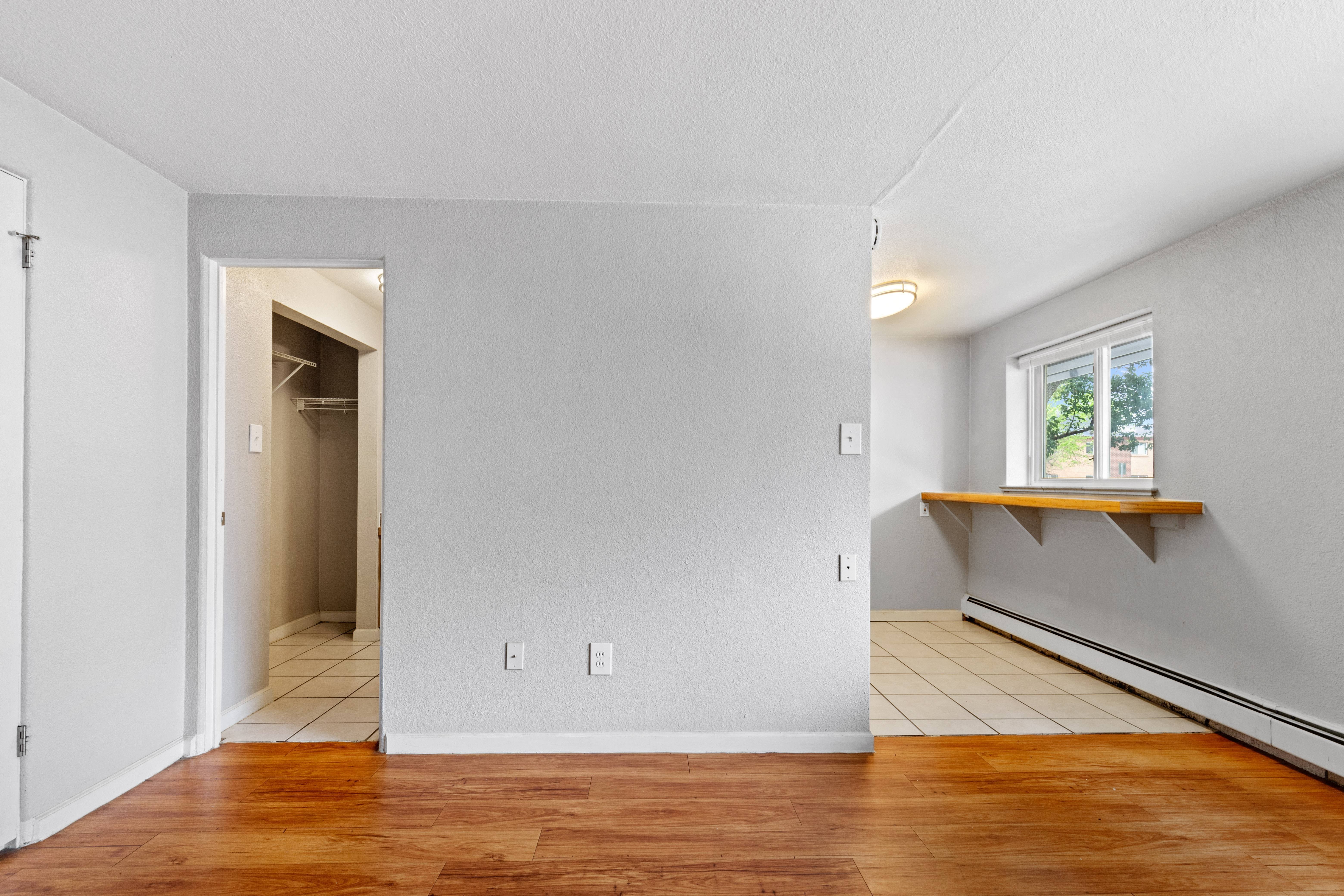 the living room and dining room of an empty house with a hard wood floor